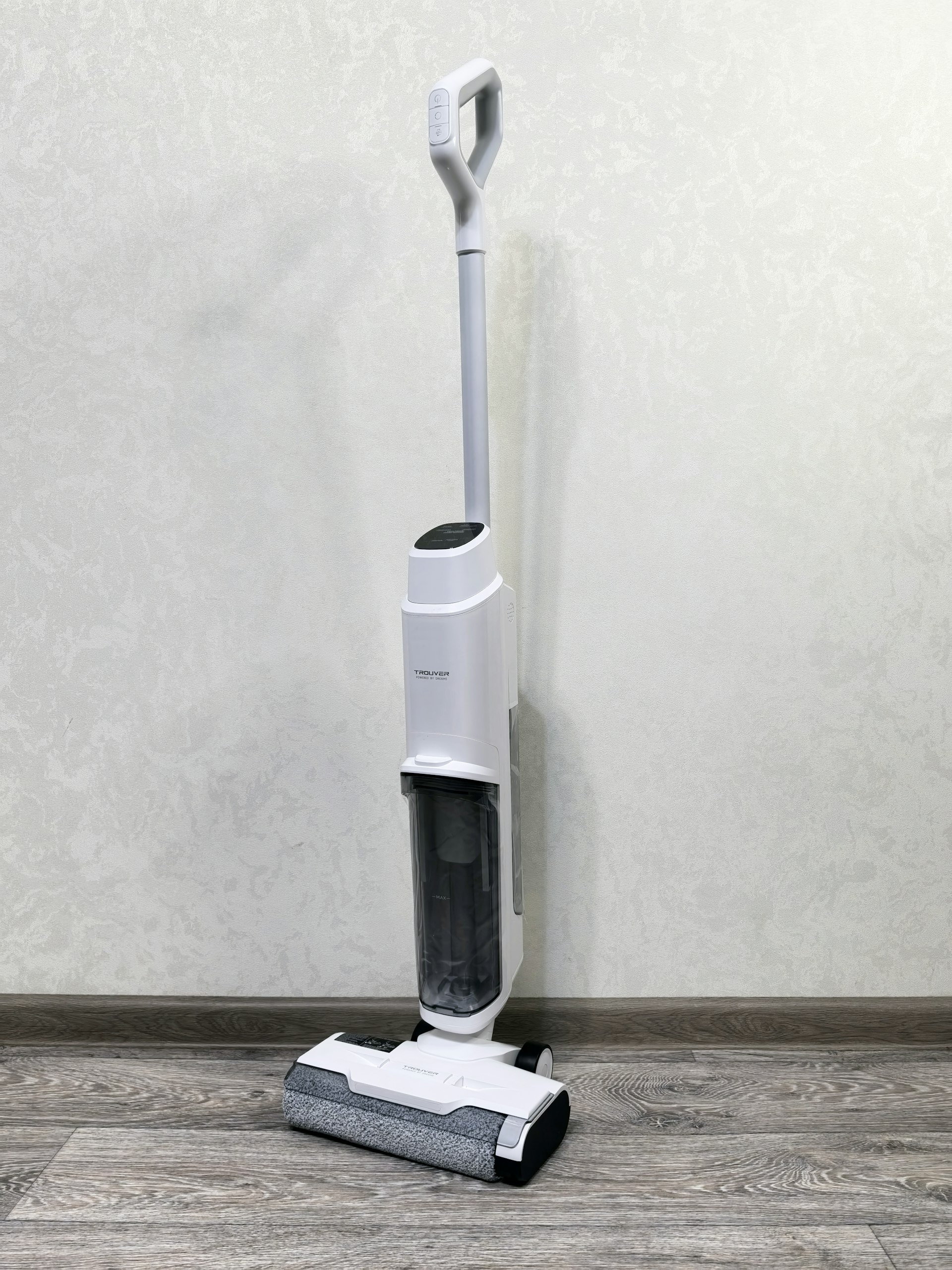 Aspirateur balai sans fil appuyé contre le mur d'un corridor lumineux